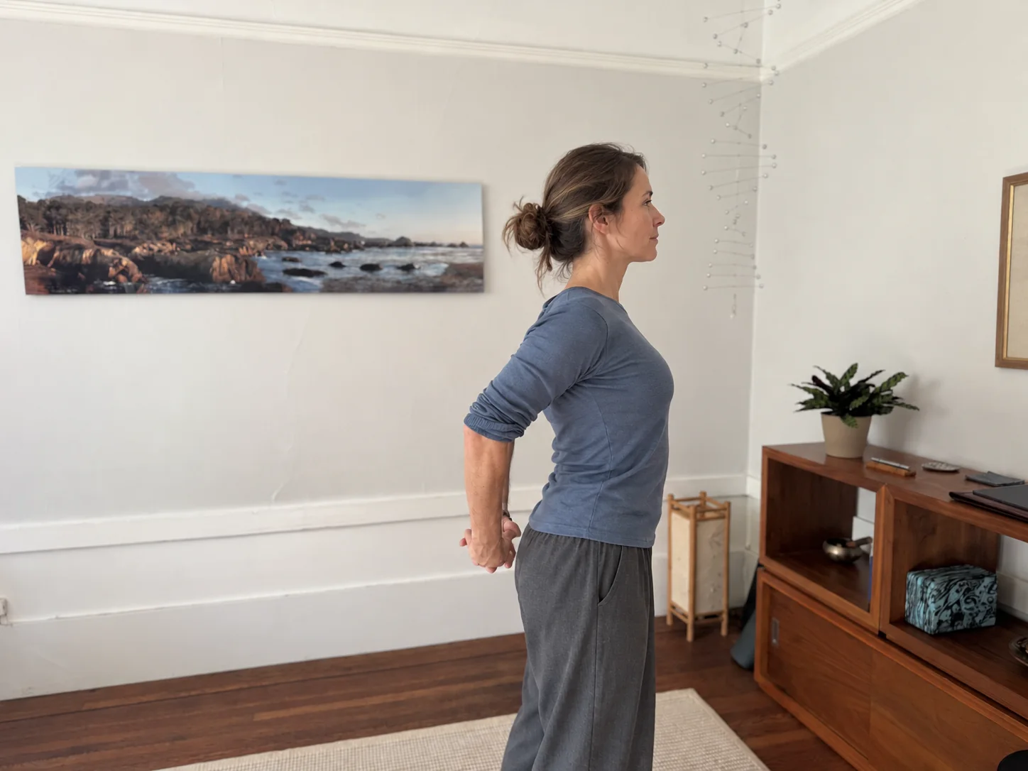 Woman in profile with hands joined behind her back